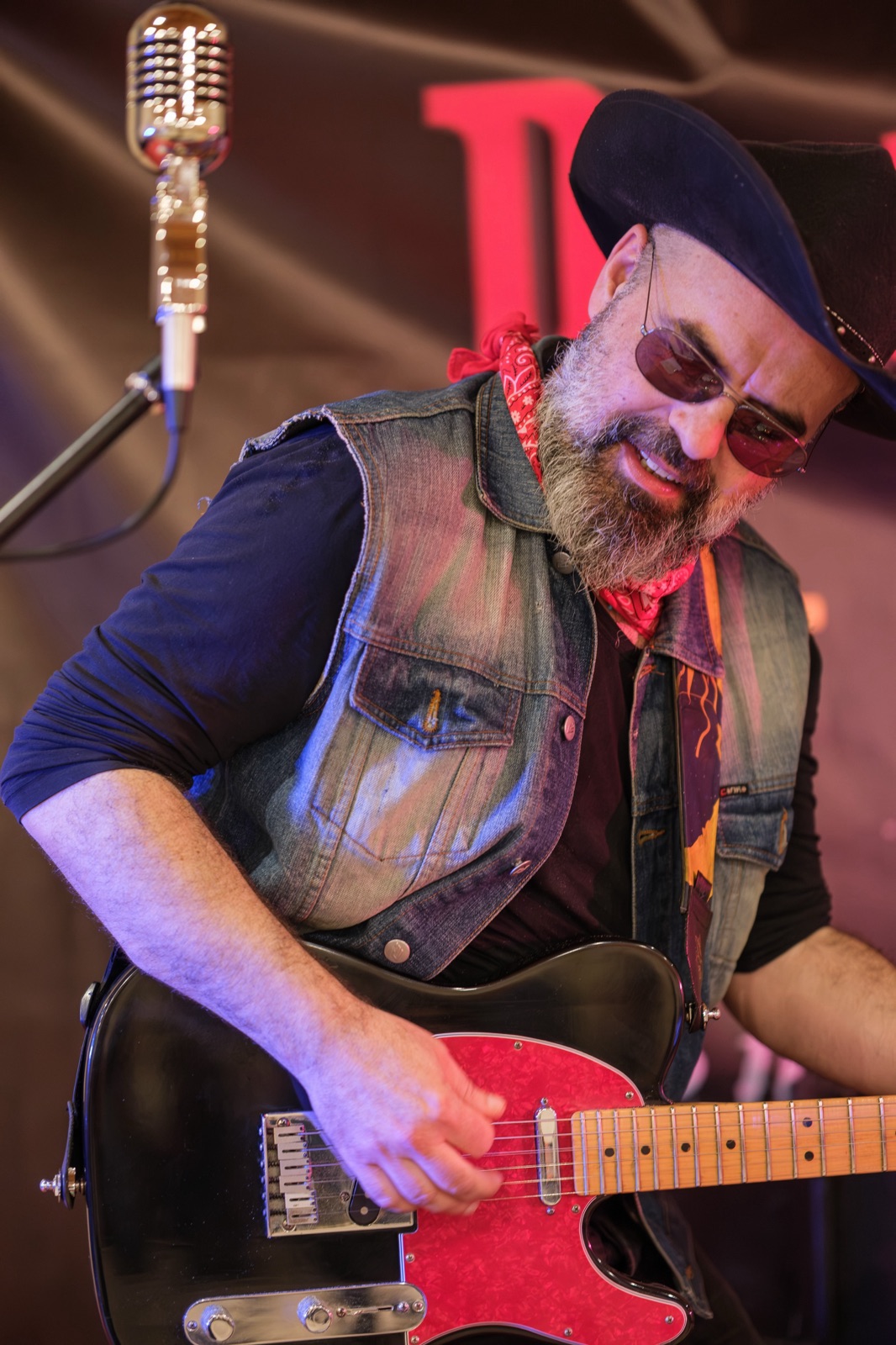 Il chitarrista con la barba e la bandana rossa suona la chitarra elettrica