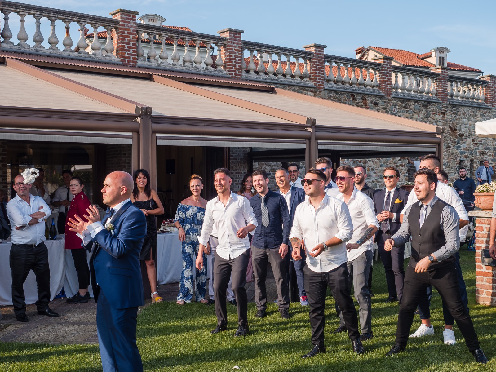 Lo sposo lancia la giarrettiera verso il gruppo degli invitati