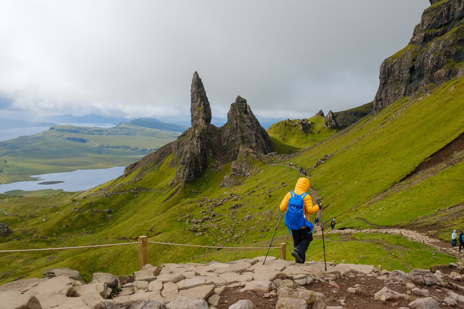 Un'escursionista con la giacca gialla sul sentiero verso l'Old Man of Storr